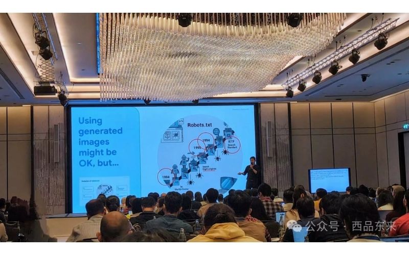 一个人在会议室中做演讲，背景有PPT显示，观众坐在座位上听讲。